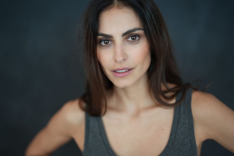 Portrait of a young woman with natural beauty in a studio setting. Soft lighting enhances her elegant features
