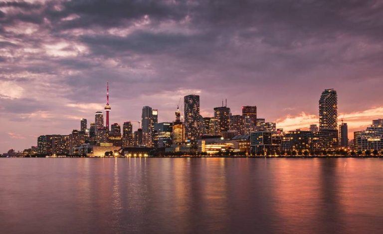 Toronto skyline glows at dawn across the waterfront