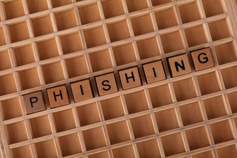Wooden Scrabble tiles arranged to spell 'Phishing', illustrating online security concepts