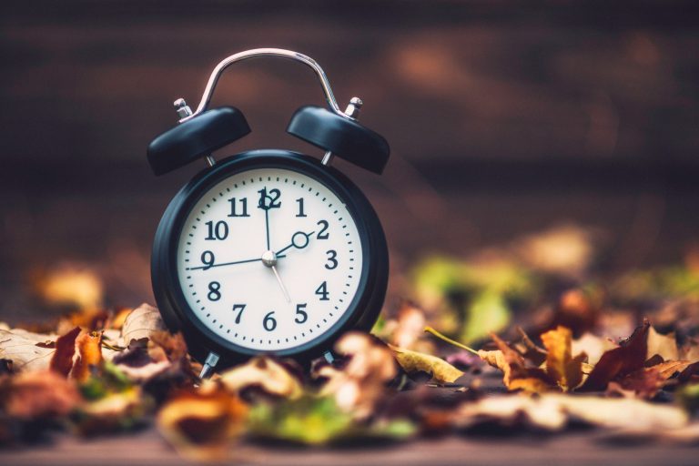 An analog alarm clock in close-up, illustrating a daylight-saving time change